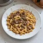 Delicious slow cooker creamy garlic beef pasta with herbs and noodles.
