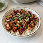 Delicious sticky chicken rice bowl with vibrant vegetables and savory sauce