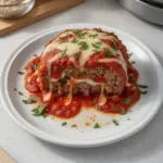 Delicious stuffed Italian meatloaf with herbs and cheese, served on a plate.