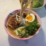 Bowl of delicious teriyaki chicken ramen topped with green onions and sesame seeds