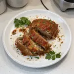 Delicious homemade meatloaf sliced and garnished on a plate