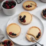 Vegan fruit tarts with custard topped with fresh fruits.