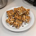 Delicious chocolate chip cheesecake bars on a wooden table