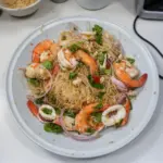 A vibrant glass noodle salad with colorful vegetables and herbs