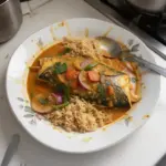 Delicious homemade fish curry served in a bowl with fresh herbs and spices.