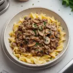Delicious Ground Venison Stroganoff served on a plate with creamy sauce and pasta.