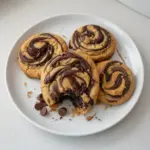 Delicious peanut butter brownie swirl cookies on a plate, topped with chocolate drizzle.