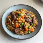 Plate of savory venison fried rice garnished with green onions