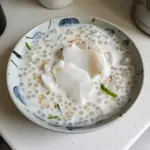 Bowl of Thai coconut sago pudding with sago pearls and coconut milk toppings.