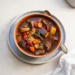 Delicious bowl of venison stew with vegetables and herbs